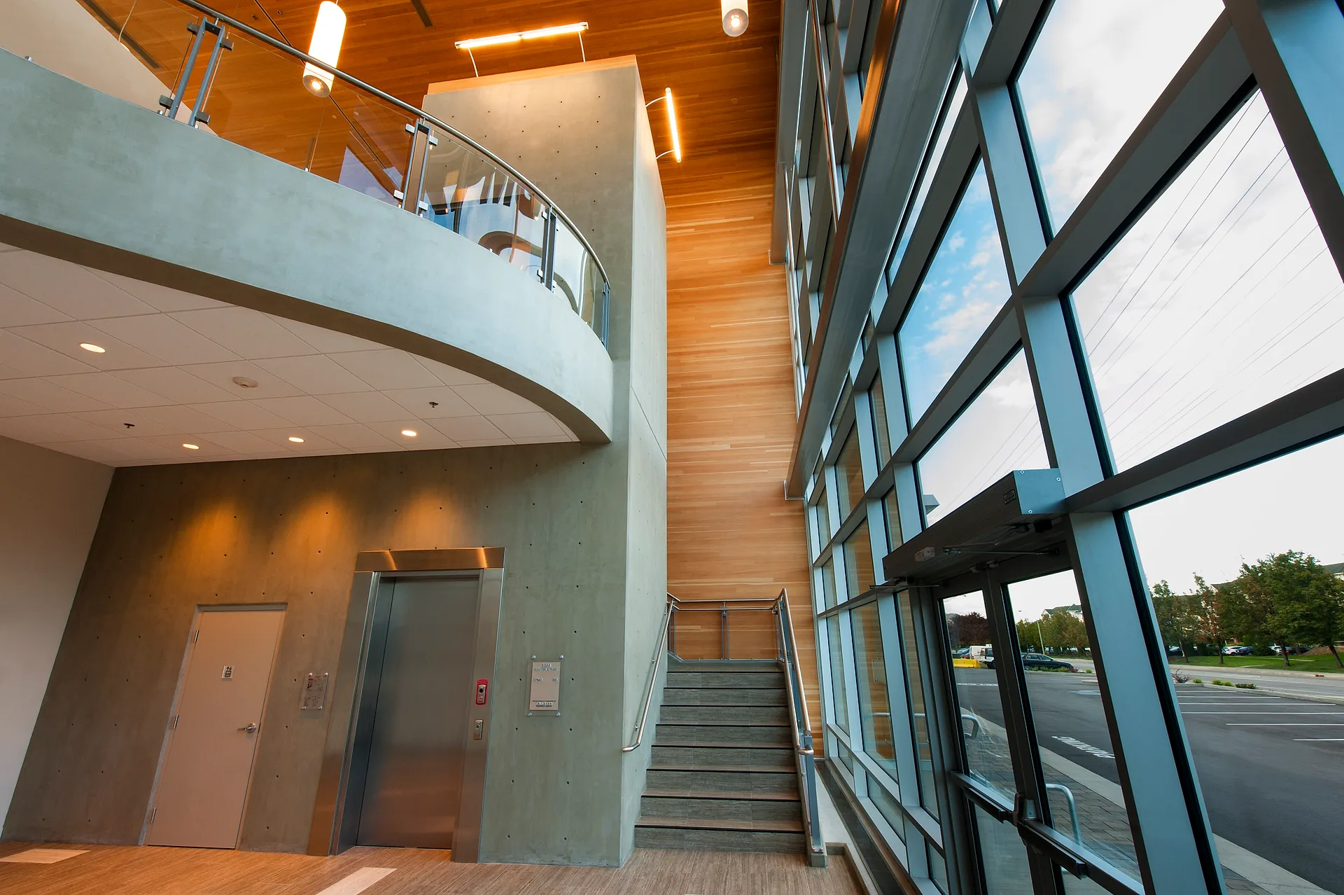 KPMG Kelowna office two-storey lobby with feature stair and full-height glazing, commercial interior design by SAGE